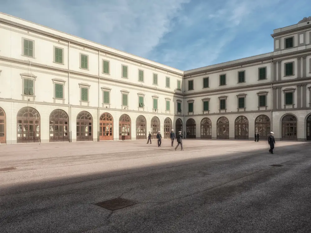 Cadetti in uniforme nel cortile storico dell'Accademia Militare, edificio simbolo della formazione per futuri ufficiali.