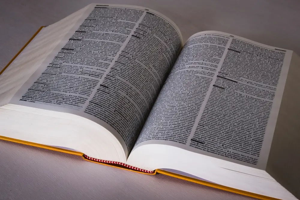 Dizionario di italiano aperto su un banco, pronto per la consultazione durante la prova scritta del concorso.