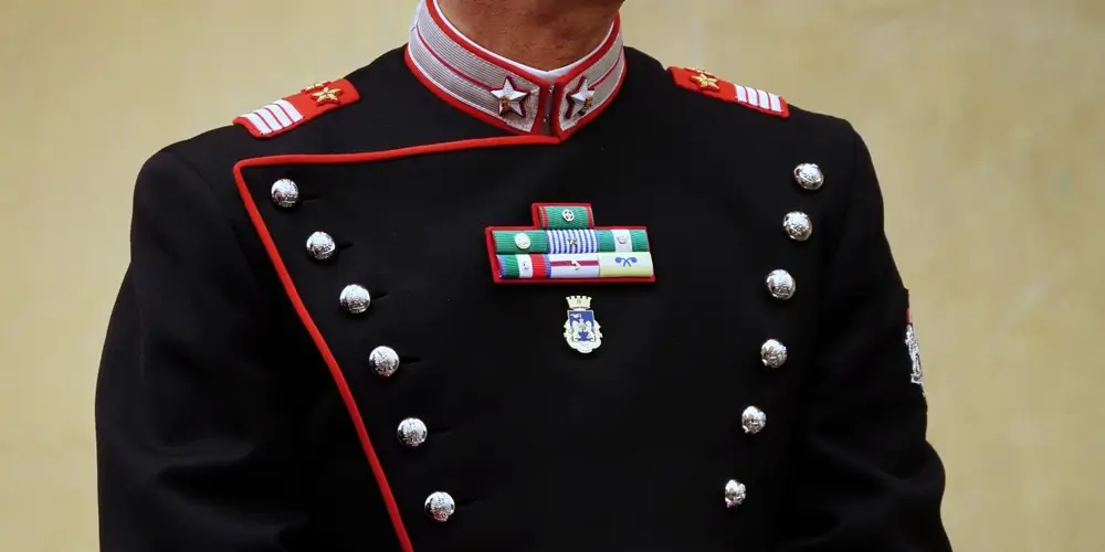 Ufficiale dell'Esercito Italiano in uniforme di rappresentanza con mostrine, gradi e decorazioni militari.
