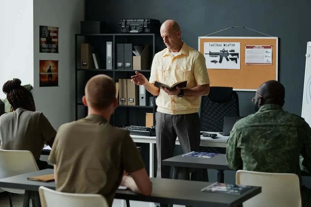 Allievi dell'Accademia Militare in aula durante una lezione teorica con un istruttore.