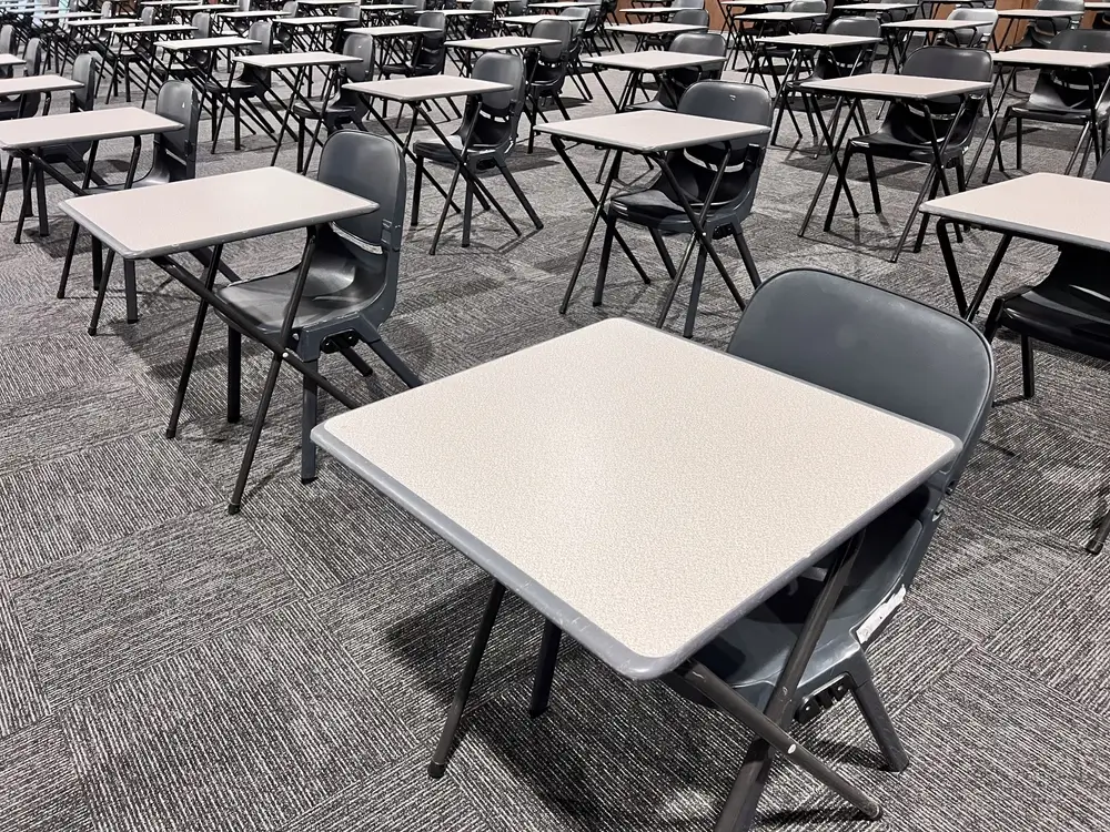 Aula d'esame con file ordinate di banchi e sedie per le prove di preselezione e concorso per l'Accademia Militare.