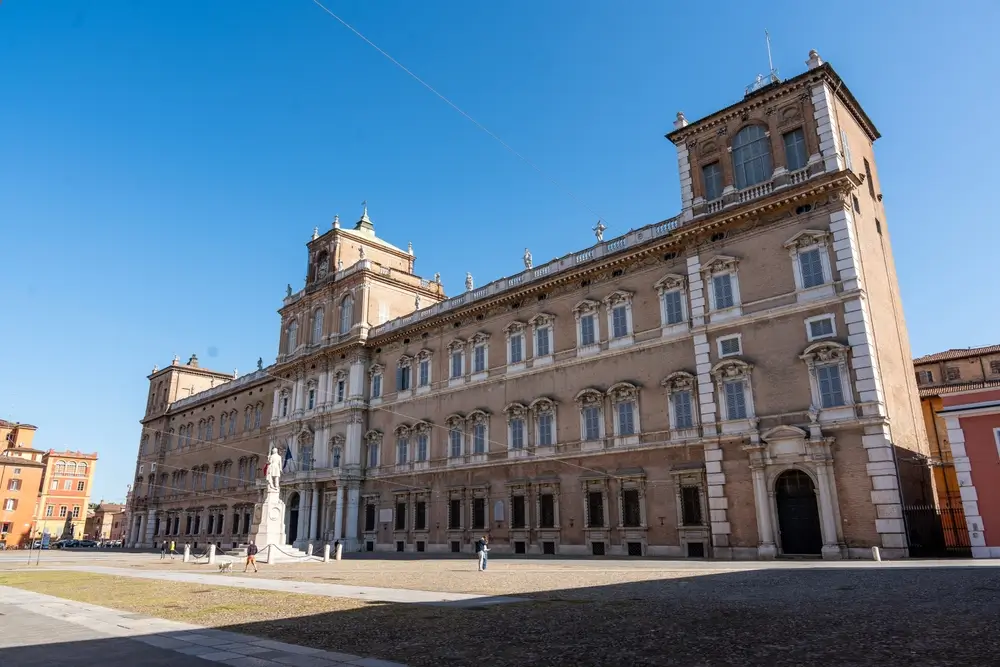 L'imponente palazzo storico dell'Accademia Militare di Modena sotto un cielo azzurro, esempio di architettura classica.