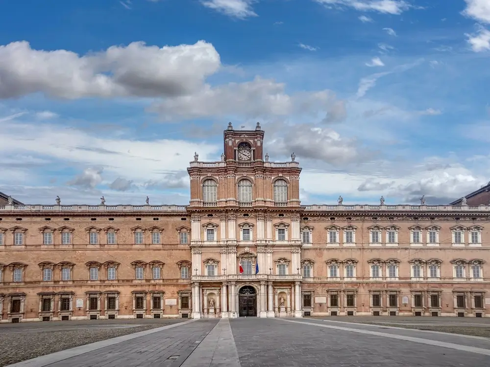Facciata del Palazzo Ducale di Modena, storica sede dell'Accademia Militare, con torre dell'orologio e cielo azzurro.