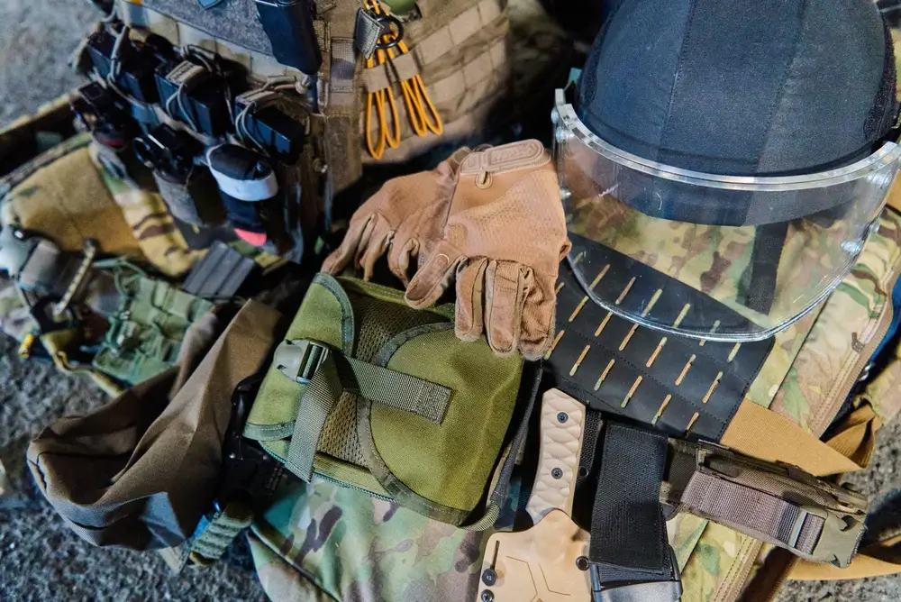 Equipaggiamento militare con zaino tattico, guanti e casco pronti per le sessioni di addestramento.