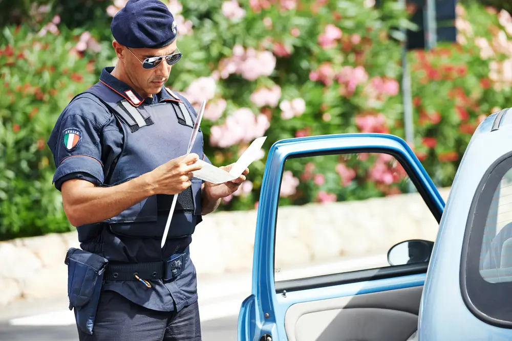 Ufficiale in uniforme mentre esamina documenti cartacei ufficiali durante una fase di controllo e verifica.